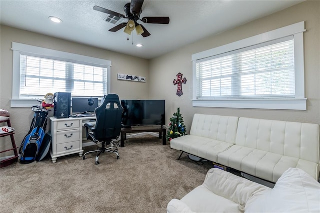 home office with light carpet, plenty of natural light, and ceiling fan