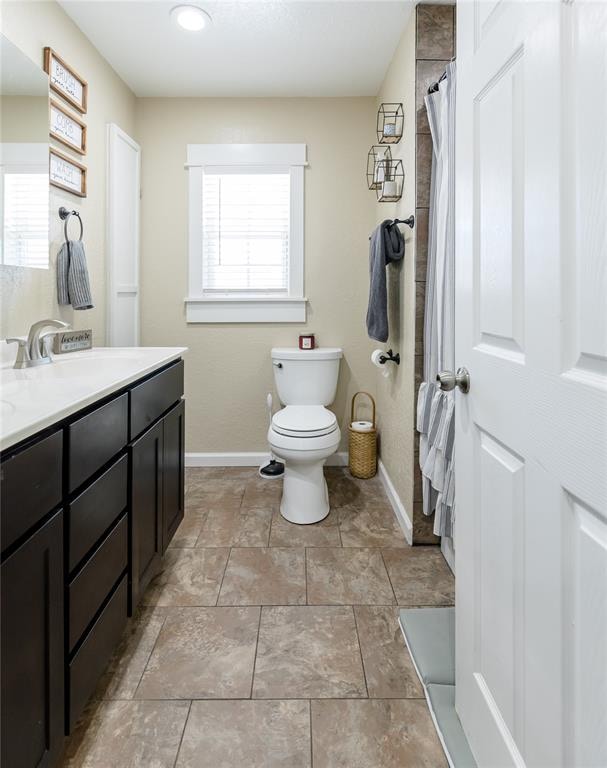 bathroom with vanity, a healthy amount of sunlight, and toilet