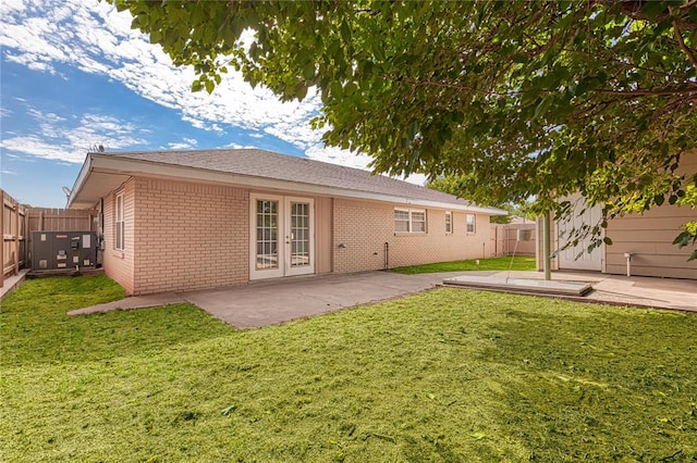 rear view of property with a lawn, french doors, and a patio