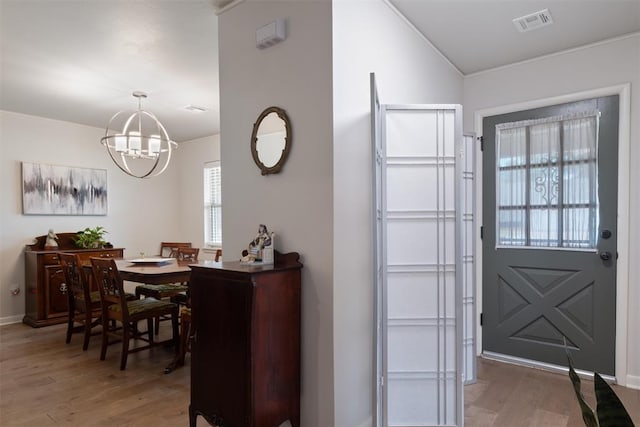 foyer with a chandelier and wood-type flooring