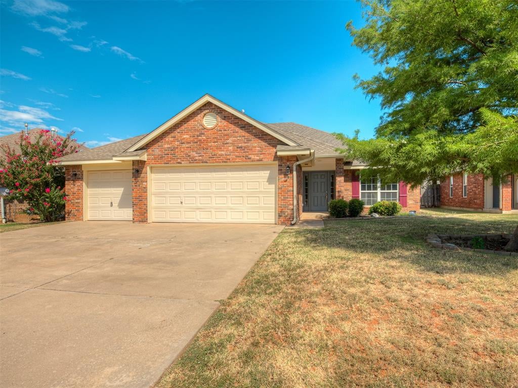 ranch-style house with a garage and a front lawn