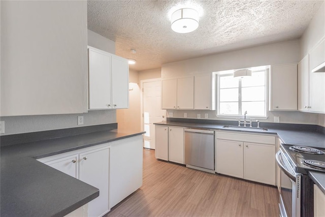 kitchen featuring light wood-type flooring, a textured ceiling, stainless steel appliances, sink, and white cabinets