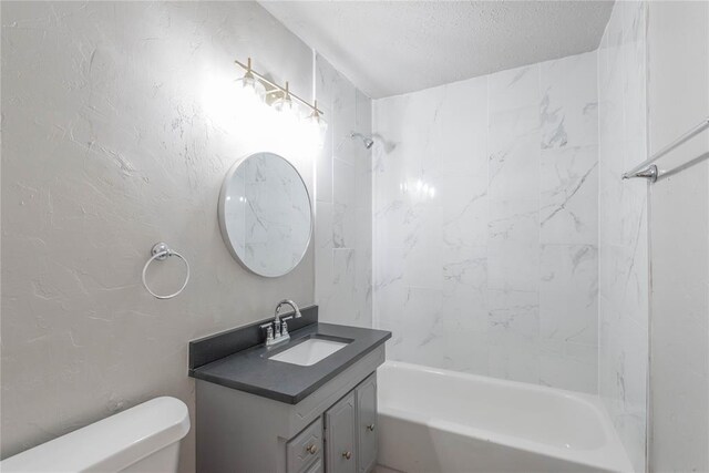 full bathroom featuring vanity, toilet, a textured ceiling, and tiled shower / bath