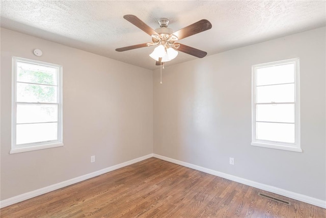 spare room with hardwood / wood-style floors, ceiling fan, and a textured ceiling