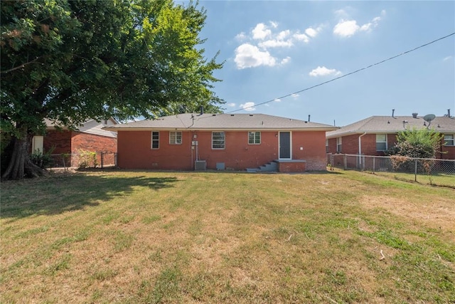 rear view of house featuring a lawn and central AC