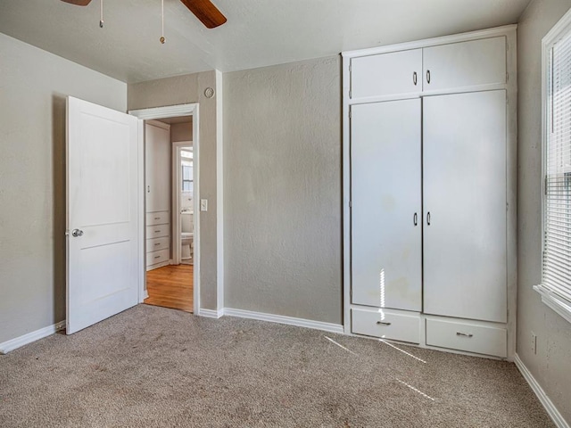 unfurnished bedroom with ceiling fan, a closet, and light colored carpet