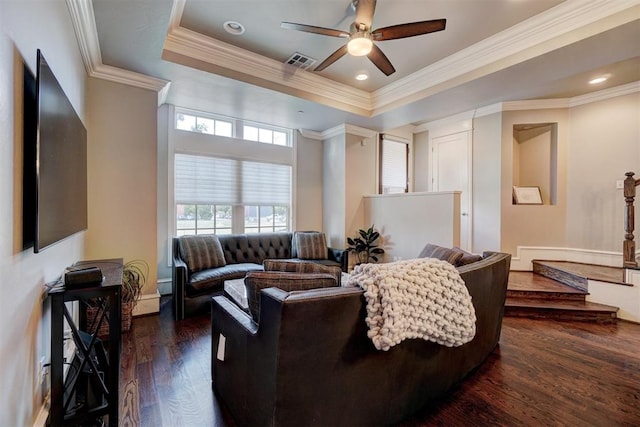 living room featuring a raised ceiling, ceiling fan, dark hardwood / wood-style flooring, and crown molding