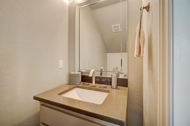 bathroom with vanity and vaulted ceiling