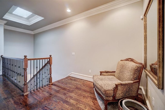 sitting room with dark hardwood / wood-style flooring, ornamental molding, and a skylight