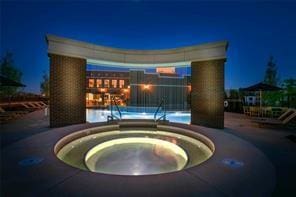 pool at night with an in ground hot tub