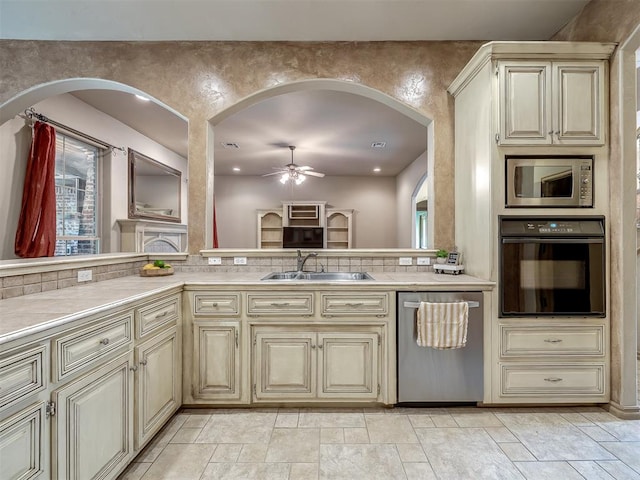 kitchen featuring ceiling fan, sink, tasteful backsplash, cream cabinetry, and appliances with stainless steel finishes