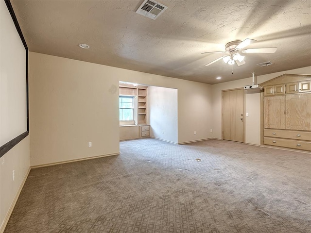 carpeted spare room with ceiling fan and a textured ceiling