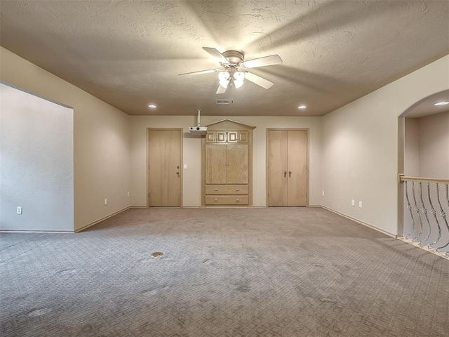 unfurnished room featuring carpet, ceiling fan, and a textured ceiling