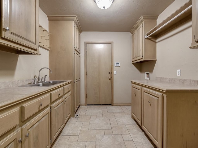 kitchen featuring sink, a textured ceiling, and light brown cabinets