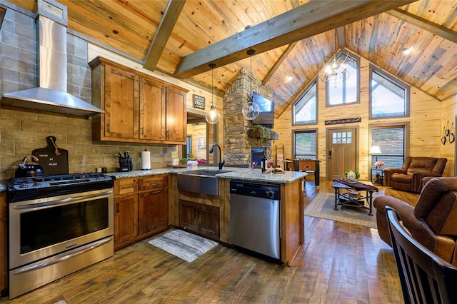 kitchen with sink, hanging light fixtures, wall chimney range hood, kitchen peninsula, and appliances with stainless steel finishes