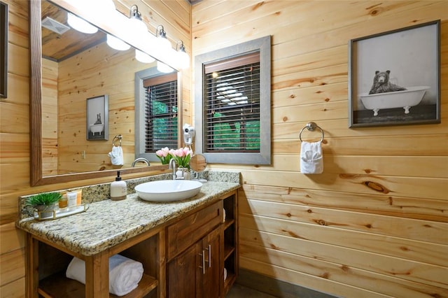 bathroom with vanity and wood walls