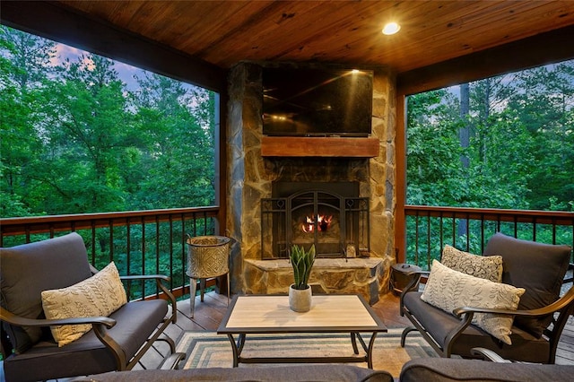 wooden terrace with an outdoor living space with a fireplace