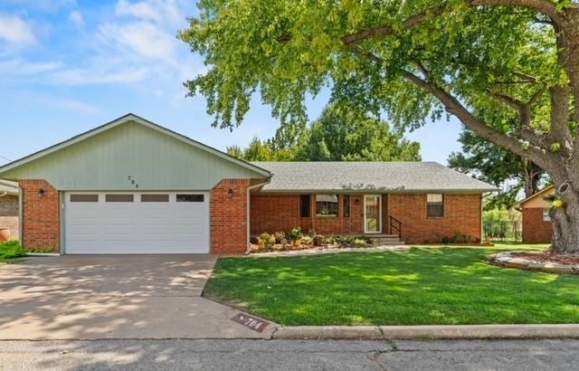 ranch-style home with a garage and a front lawn