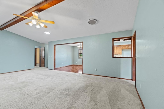 carpeted empty room featuring vaulted ceiling with beams and ceiling fan