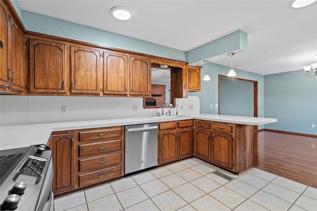 kitchen with light wood-type flooring, decorative light fixtures, kitchen peninsula, stainless steel appliances, and a chandelier