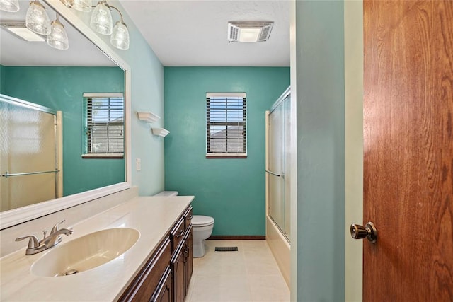 full bathroom featuring tile patterned flooring, vanity, toilet, and bath / shower combo with glass door