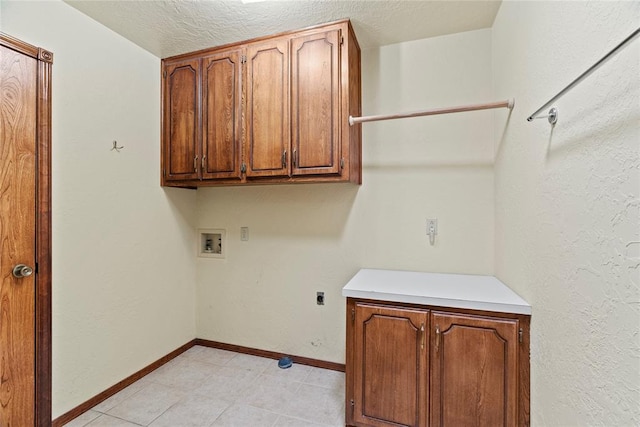 laundry area with electric dryer hookup, cabinets, a textured ceiling, and hookup for a washing machine