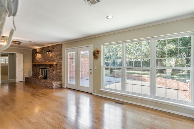 unfurnished living room featuring a fireplace, light hardwood / wood-style floors, and ornamental molding