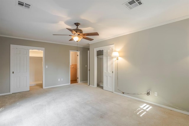 unfurnished bedroom with carpet flooring, a spacious closet, ceiling fan, and ornamental molding