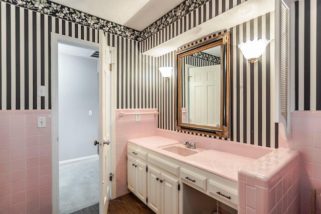 bathroom with vanity and tile walls