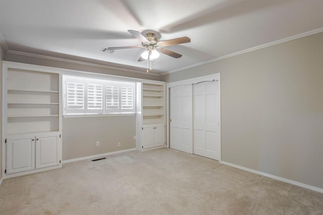 unfurnished bedroom featuring ceiling fan, crown molding, light carpet, and a closet