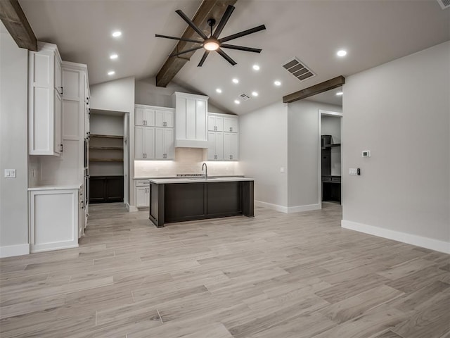 kitchen with white cabinetry, ceiling fan, a kitchen island with sink, and light wood-type flooring