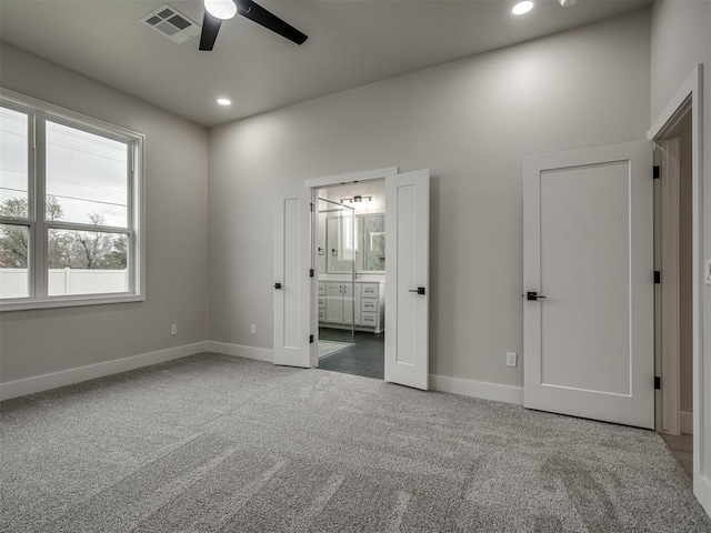 unfurnished bedroom with ensuite bathroom, ceiling fan, and carpet flooring