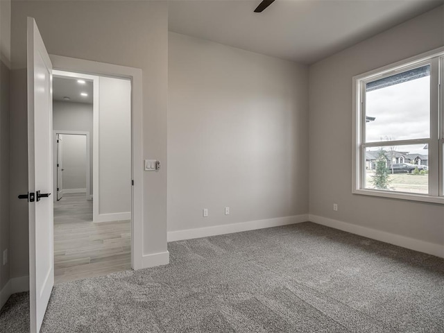 empty room with ceiling fan and light colored carpet