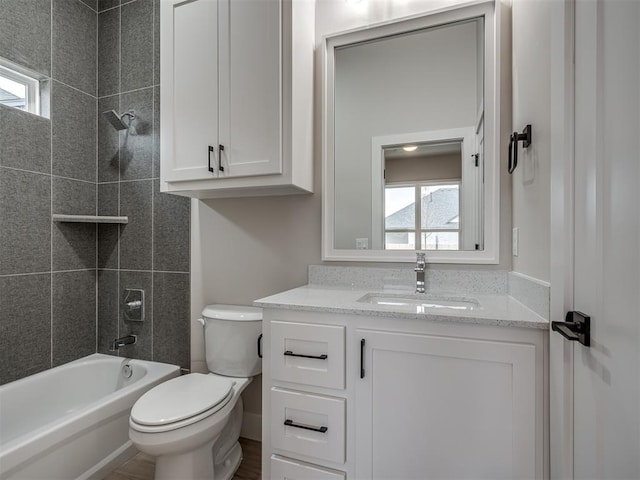 full bathroom with vanity, tiled shower / bath combo, and toilet