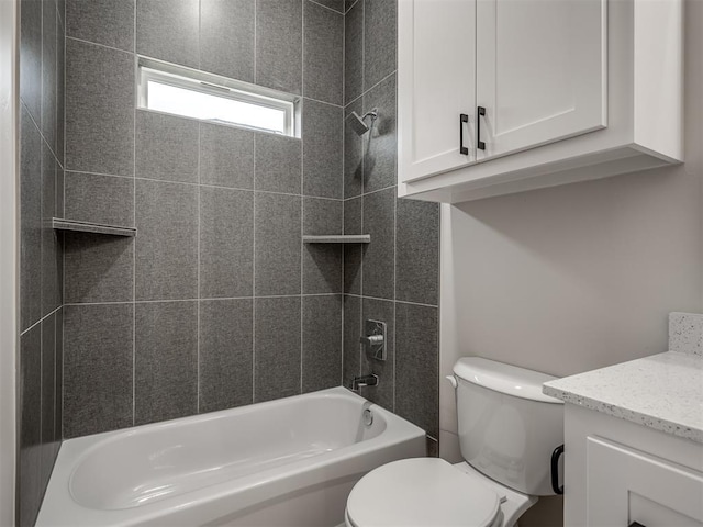 full bathroom with tiled shower / bath, vanity, and toilet