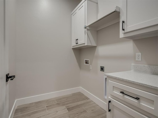 clothes washing area featuring cabinets, washer hookup, light wood-type flooring, and electric dryer hookup