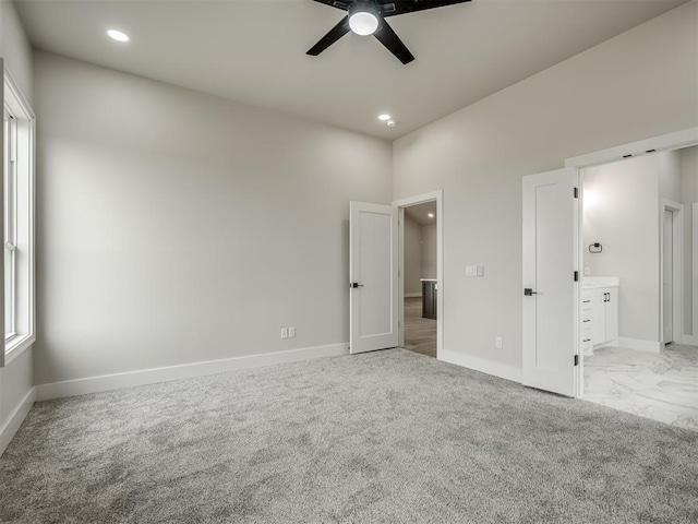 unfurnished bedroom featuring connected bathroom, light carpet, and ceiling fan