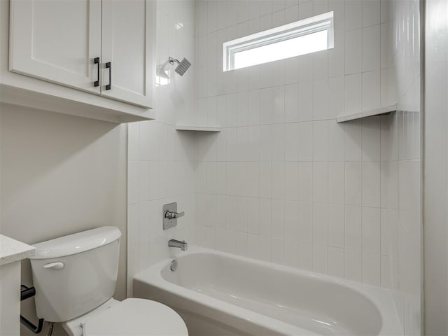 bathroom featuring tiled shower / bath combo and toilet