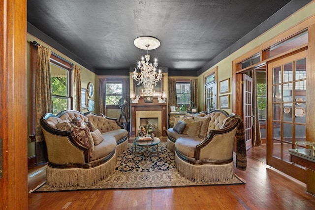 living room featuring french doors, an inviting chandelier, and hardwood / wood-style flooring