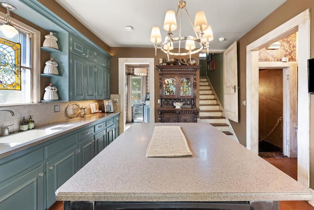 kitchen featuring sink, a center island, dark wood-type flooring, tasteful backsplash, and a notable chandelier