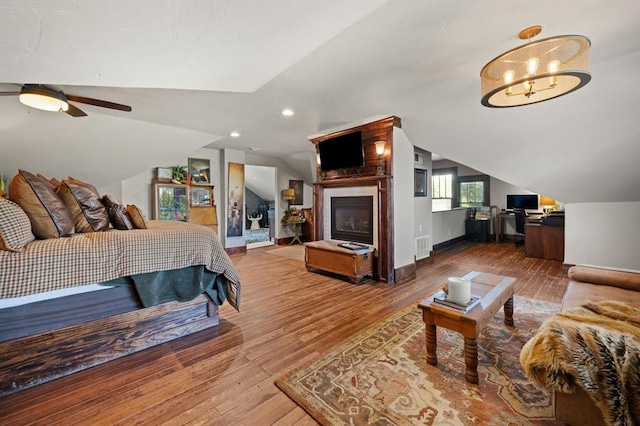 bedroom with ceiling fan, vaulted ceiling, and hardwood / wood-style flooring