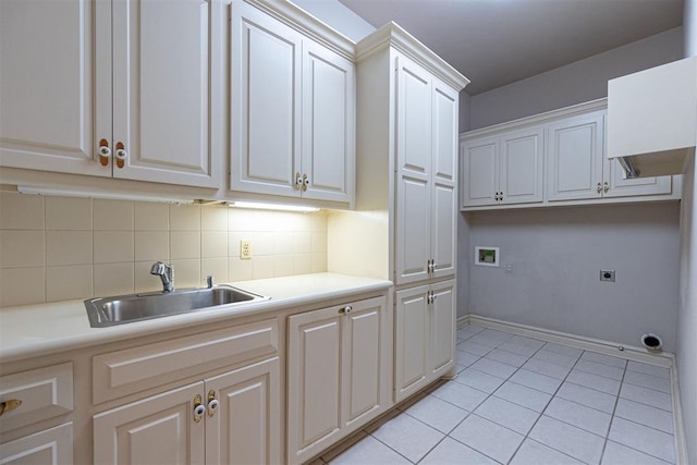 kitchen with light tile patterned flooring, sink, white cabinetry, and backsplash