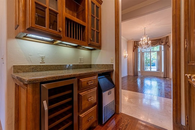 bar with dark hardwood / wood-style flooring, ornamental molding, wine cooler, and a chandelier