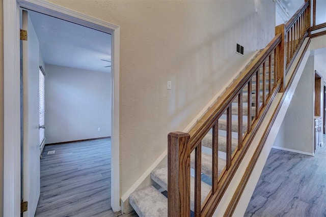 stairs featuring hardwood / wood-style floors