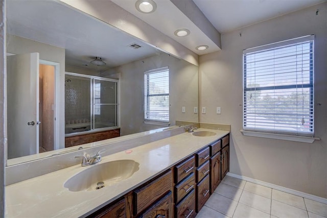 bathroom with tile patterned floors, vanity, a healthy amount of sunlight, and a shower with door