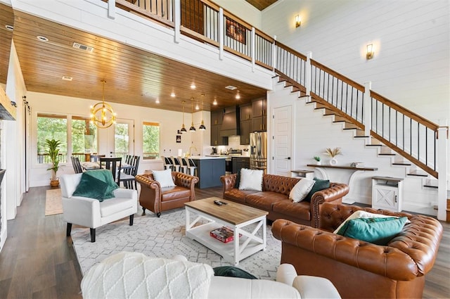 living room featuring wooden ceiling, an inviting chandelier, sink, a towering ceiling, and light hardwood / wood-style floors