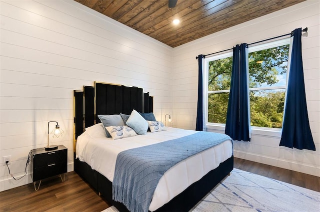 bedroom with dark hardwood / wood-style floors, wooden ceiling, wooden walls, and multiple windows