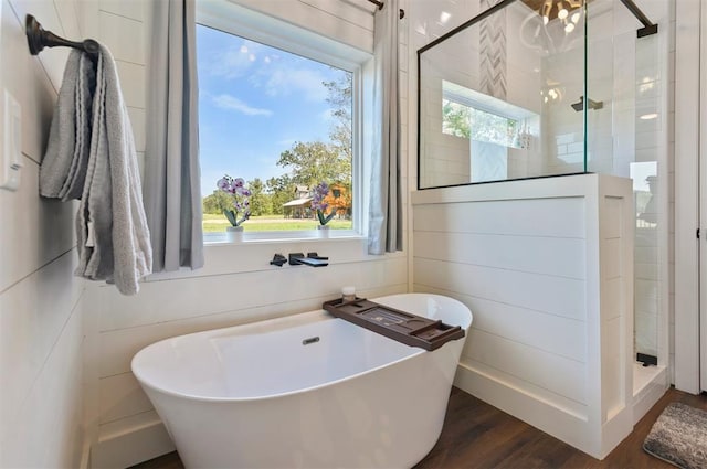 bathroom featuring hardwood / wood-style flooring, a wealth of natural light, and independent shower and bath