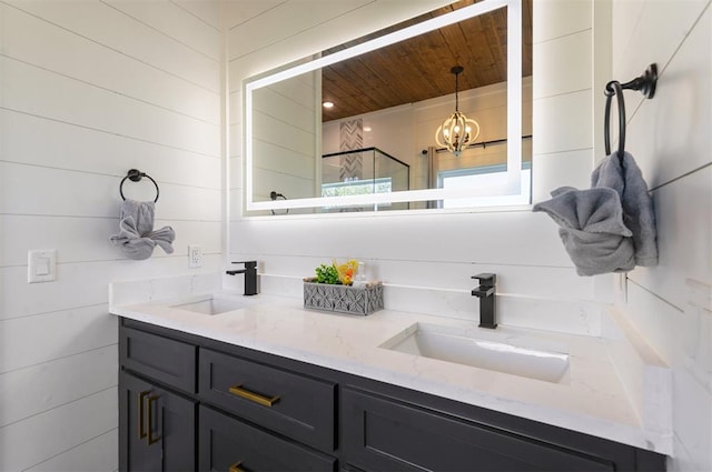 bathroom featuring vanity, a chandelier, and walk in shower