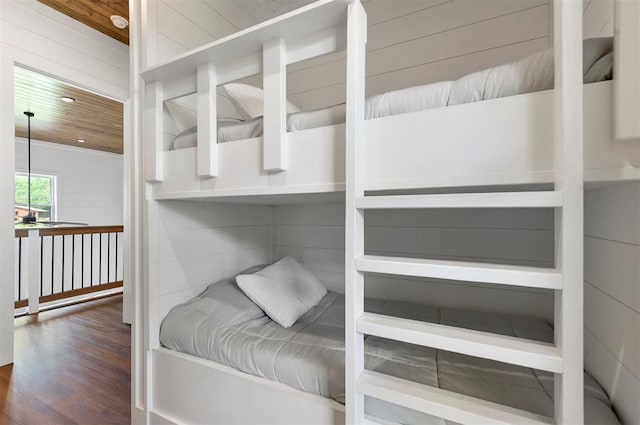 bedroom featuring dark hardwood / wood-style floors, wood ceiling, and wooden walls